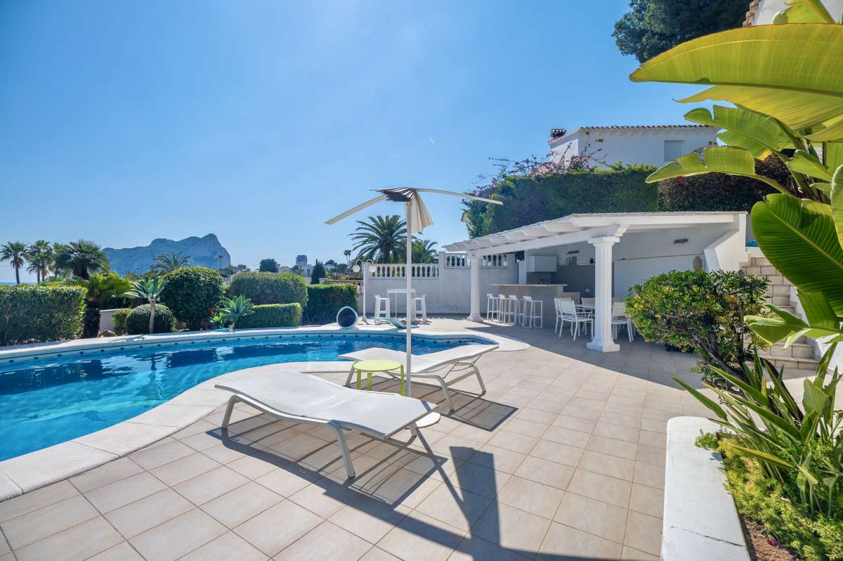 Private pool terrace with sun lounger, covered seating area, sea views, and Peñón de Ifach views at a villa in Calpe.