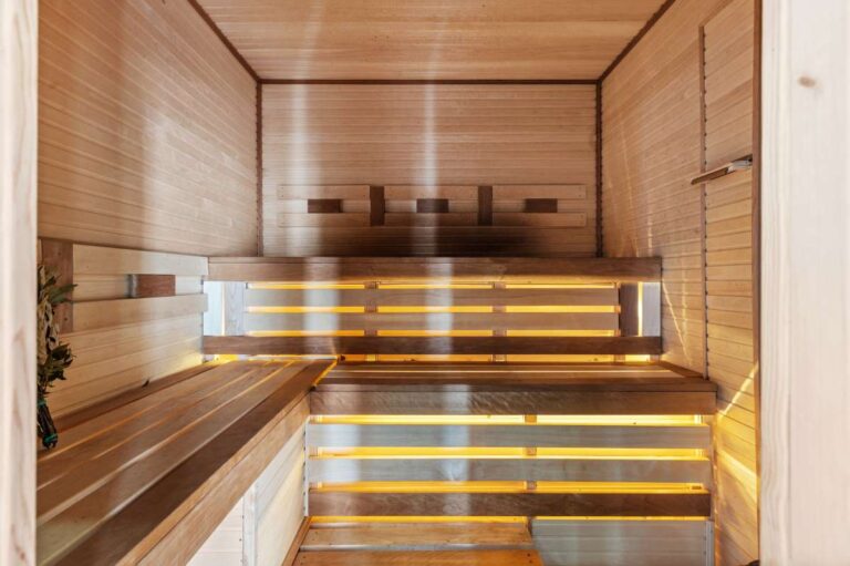 Private sauna inside a single-level modern villa in Santa Clara, Altea with wooden interior, bench seating and warm integrated lighting