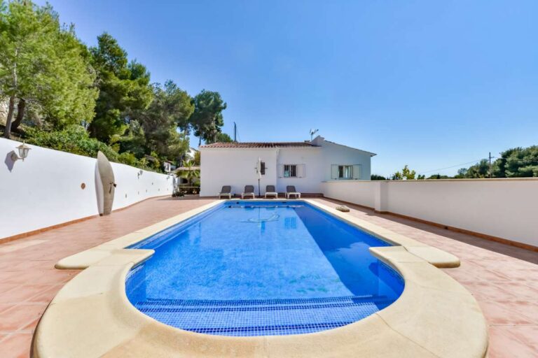 Private swimming pool at a charming Benissa Coast villa with spacious sun terrace, garden walls, sun loungers and Mediterranean planting