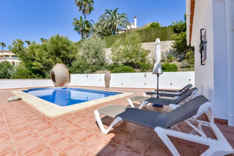Private swimming pool at a charming Benissa Coast villa with sun loungers, tiled terrace, Mediterranean planting and surrounding garden