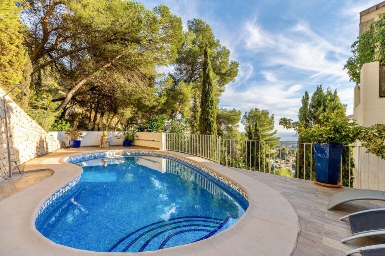 Private swimming pool at a panoramic sea view villa in Benissa with terrace area, Mediterranean planting and open views across the hills
