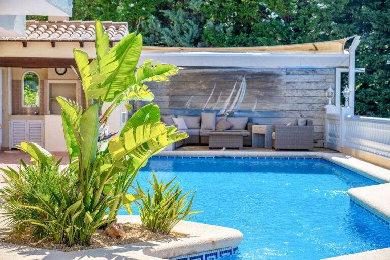 Private swimming pool at an elegant Mediterranean villa in Altea Hills with terrace seating, tropical planting and outdoor relaxation area
