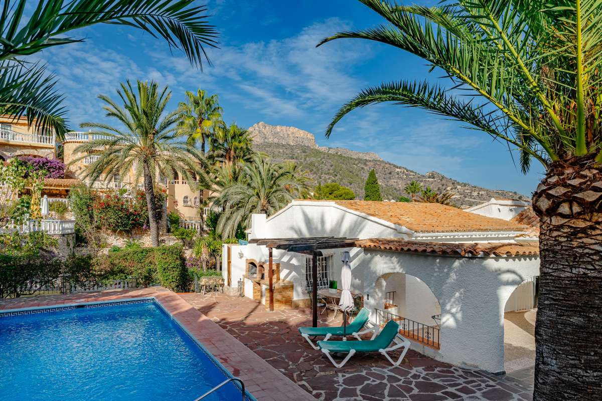 Private swimming pool with outdoor dining area, BBQ space and mountain views at a Mediterranean villa in Maryvilla, Calpe.