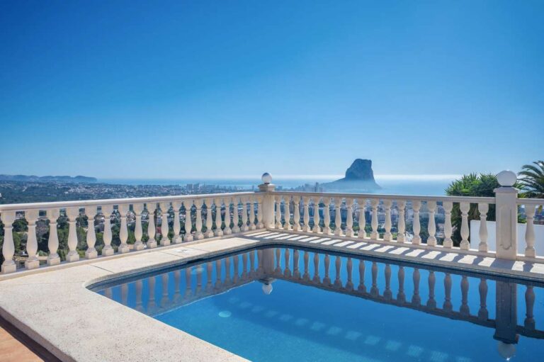 Private swimming pool with sea views and the Peñón de Ifach in the distance at a villa in Calpe.