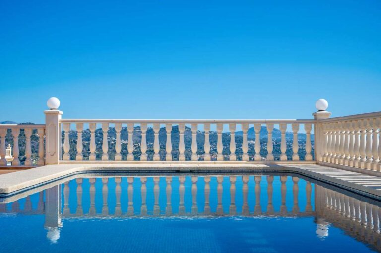 Private swimming pool with sea views and white balustrade at a villa in Calpe.