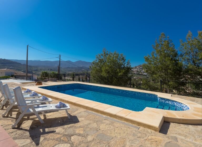 Private swimming pool with sunny terrace and mountain views at a Mediterranean villa in Calpe.