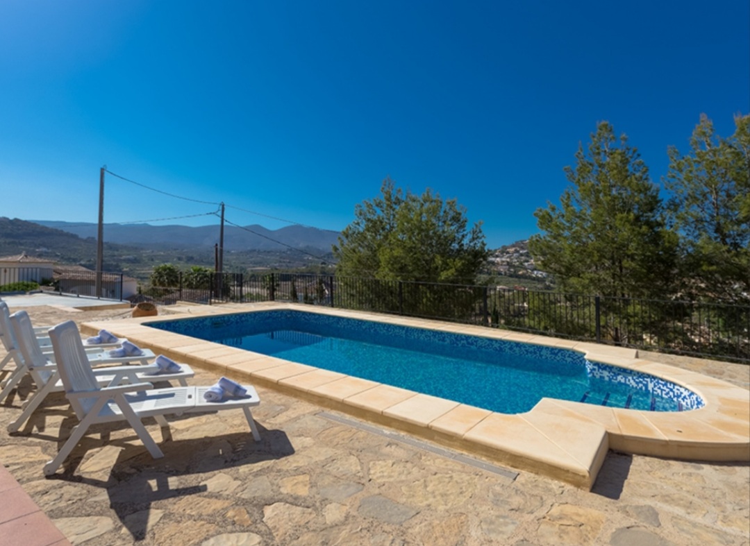 Private swimming pool with sunny terrace and mountain views at a Mediterranean villa in Calpe.