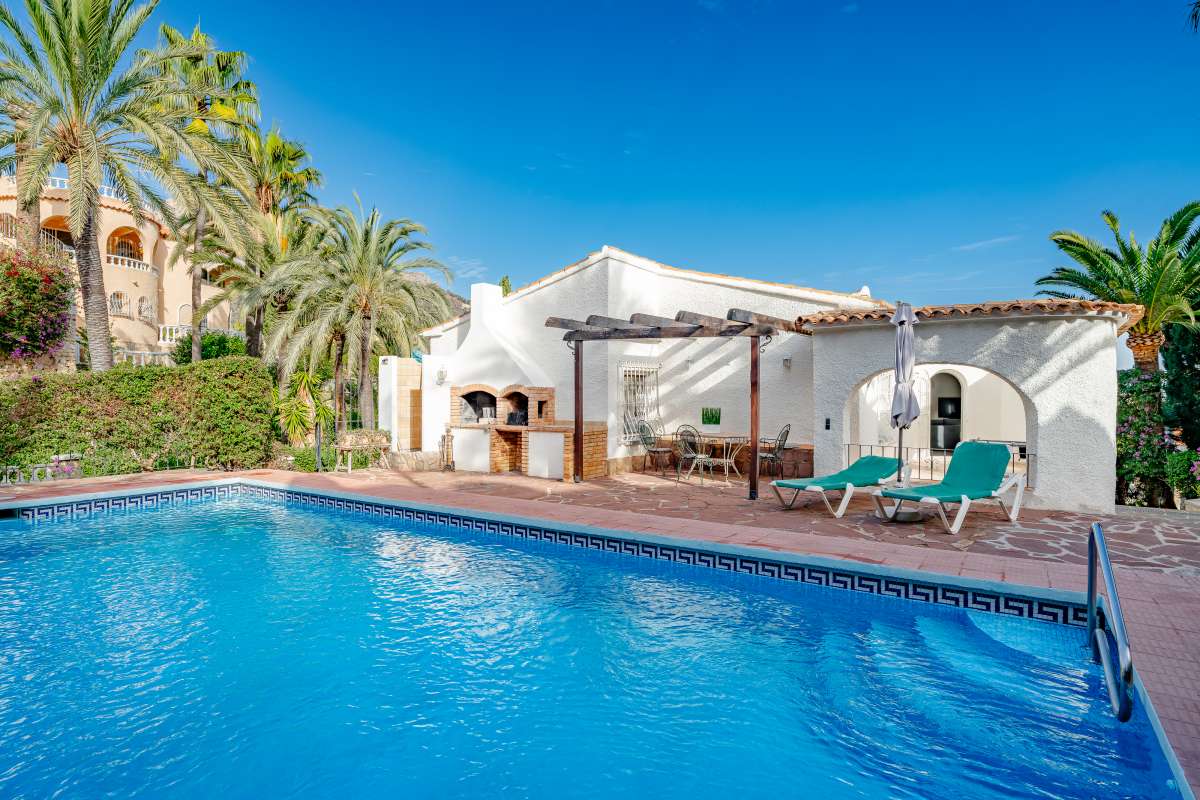 Private swimming pool with terrace, BBQ area and Mediterranean planting at a villa in Maryvilla, Calpe.