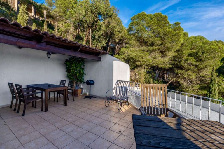 Private terrace at a panoramic sea view villa in Benissa with outdoor dining area, sun loungers and views towards pine trees