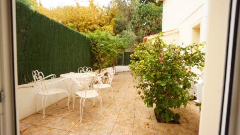 Private tiled terrace with outdoor seating and greenery at a villa near La Fustera beach.
