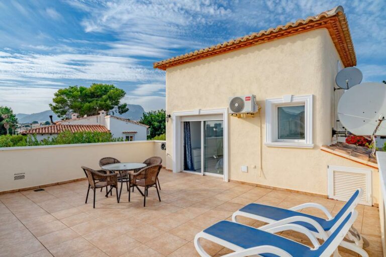 Rooftop terrace at a villa in Calpe with outdoor dining area, sun loungers and open residential views