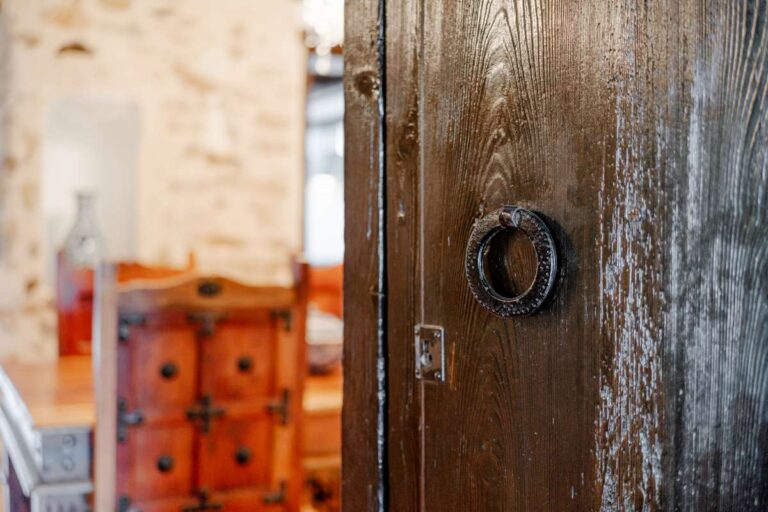 Rustic wooden door detail inside a historic finca in Benissa with traditional Mediterranean character and stone interior beyond