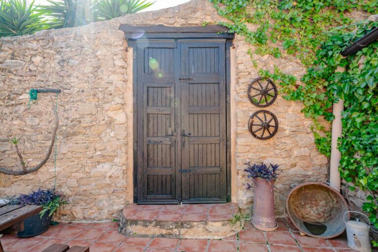 Rustic wooden entrance at a historic finca in Benissa with stone walls, traditional doorway and Mediterranean courtyard details