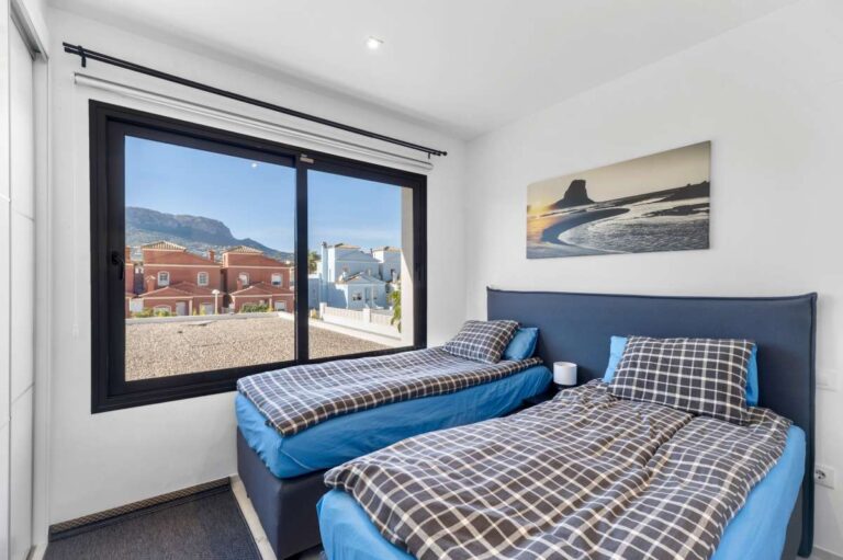 Second bedroom with twin beds, fitted wardrobe and open views inside a modern oasis villa in Calpe.