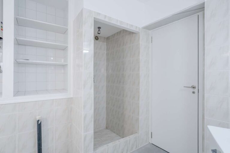 Shower area with tiled walls and white finishes inside a Mediterranean villa in Maryvilla, Calpe.