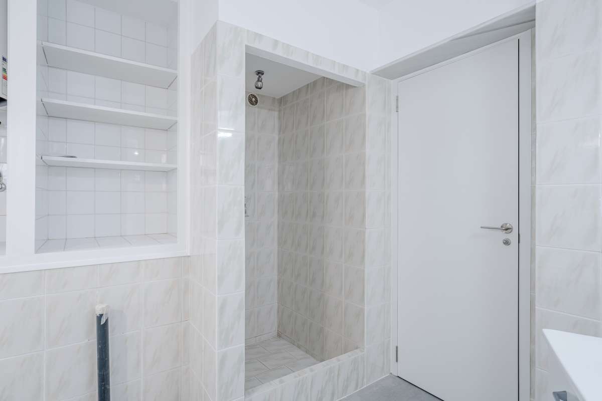 Shower area with tiled walls and white finishes inside a Mediterranean villa in Maryvilla, Calpe.