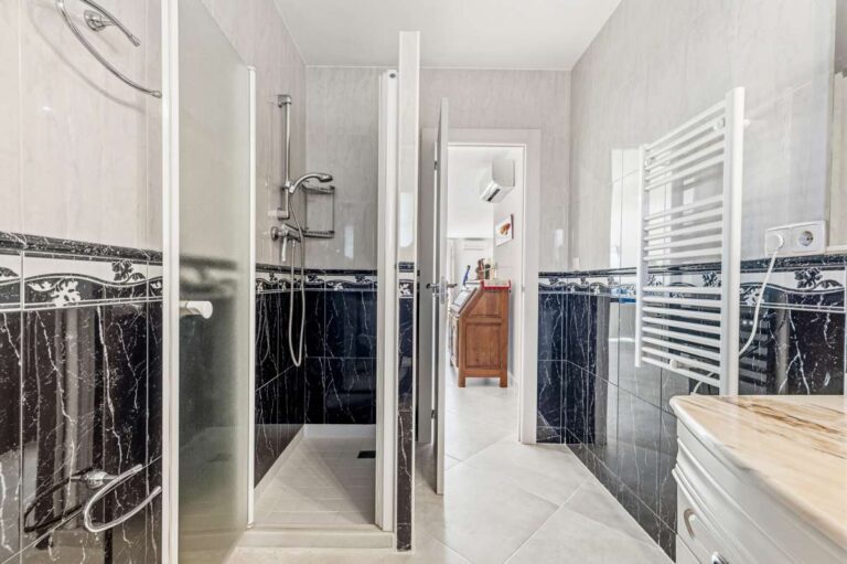 Shower room with walk-in shower, towel radiator and modern fittings inside a contemporary villa in Calpe.