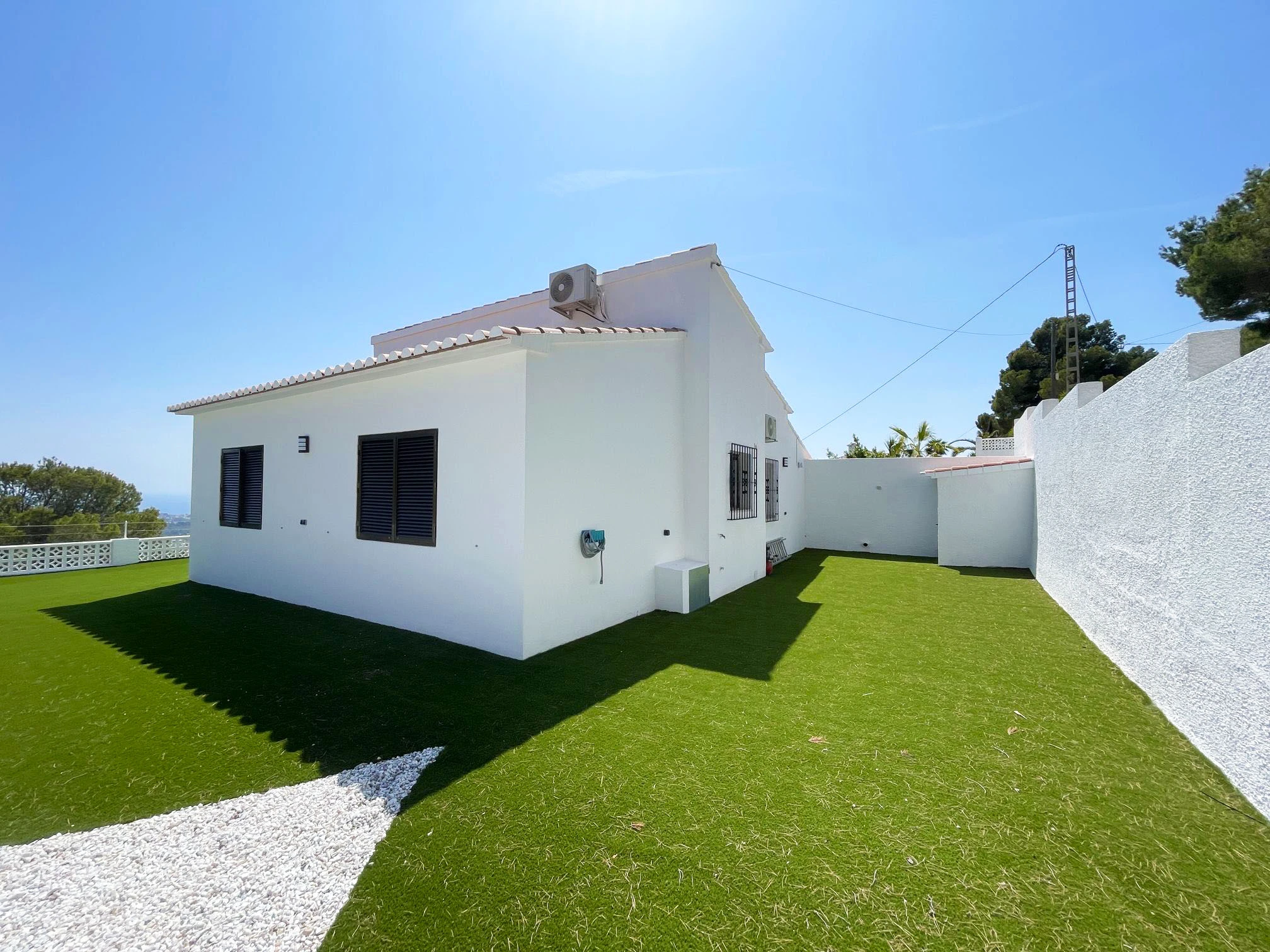 Side garden and white villa exterior in Oltamar, Calpe