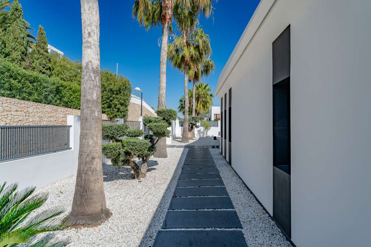 Side garden pathway with palm trees and low-maintenance landscaping at a luxury villa in Gran Sol, Calpe.