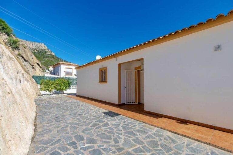 Side terrace and exterior walkway beside a villa in Calpe with mountain surroundings.