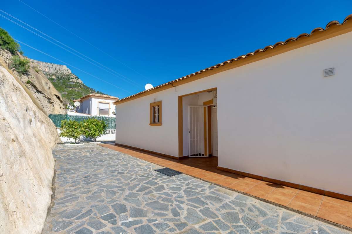 Side terrace and exterior walkway beside a villa in Calpe with mountain surroundings.