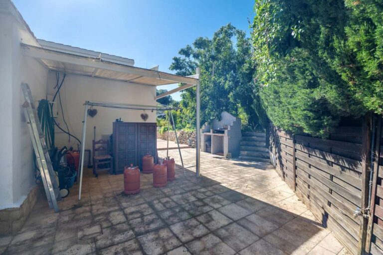 Side terrace at a Mediterranean villa in Benissa Costa near Cala Baladrar with storage area, stone paving and garden access