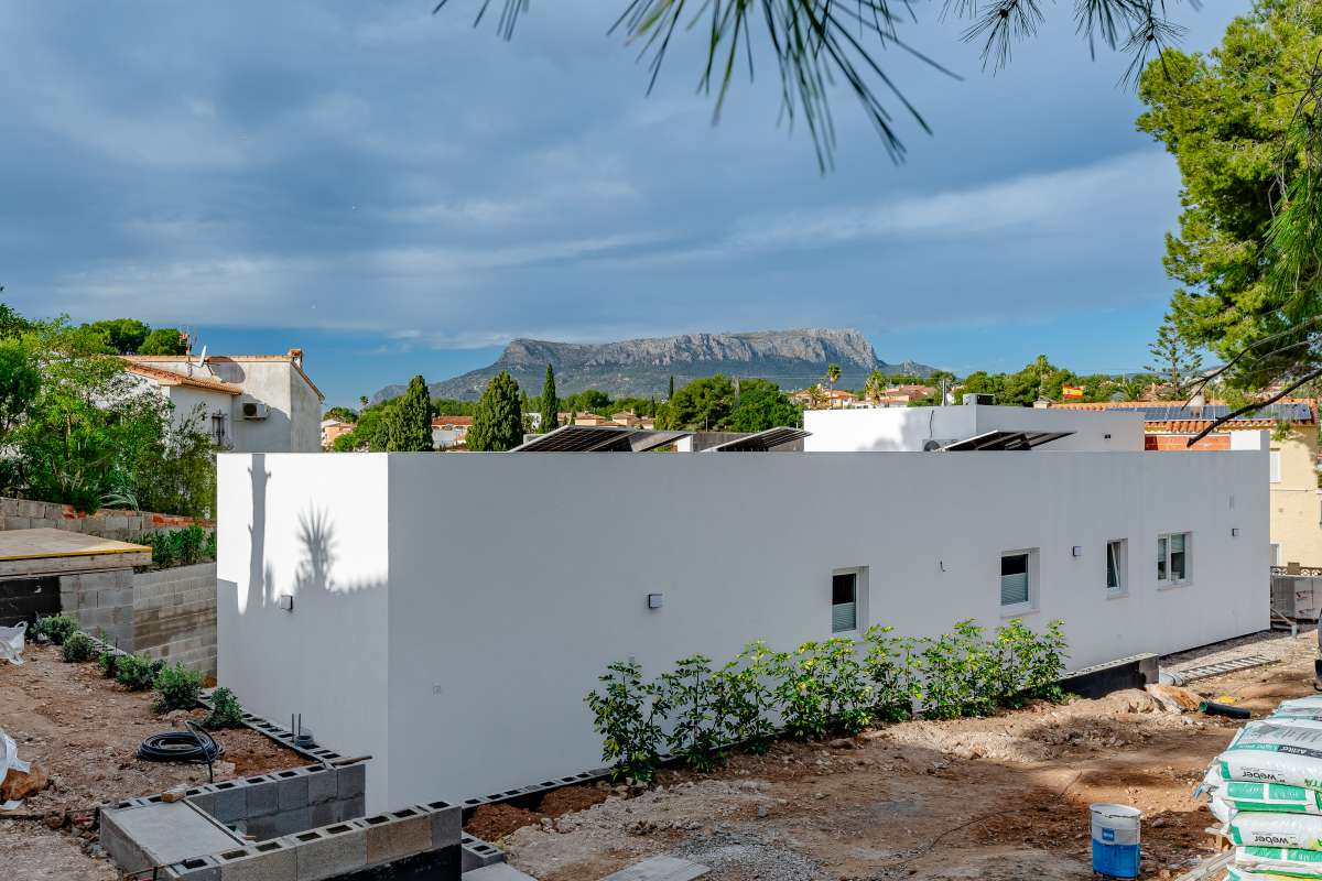 Side view of a modern new build villa in Calpe with private outdoor space and surrounding trees