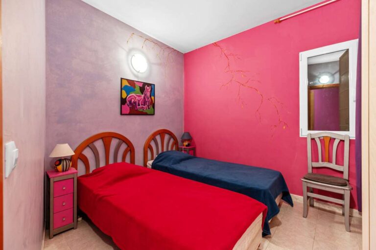 Single bedroom inside an independent apartment of a Benissa sea view villa with bright wall finish, wooden bed frame and compact layout