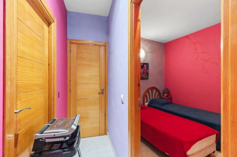 Single bedroom inside an independent apartment of a Benissa sea view villa with wooden door, bright wall finish and compact layout