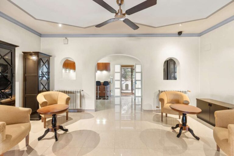 Sitting area inside a private villa for sale in Calpe with armchairs, tiled floor, arched doorways and bright interior space