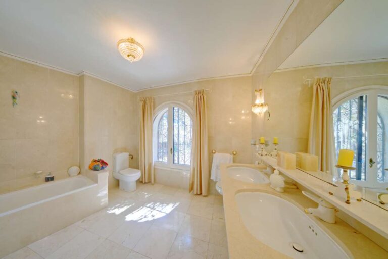 Spacious bathroom with bath, vanity and natural light inside a second line Mediterranean villa near Puerto Blanco in Calpe.