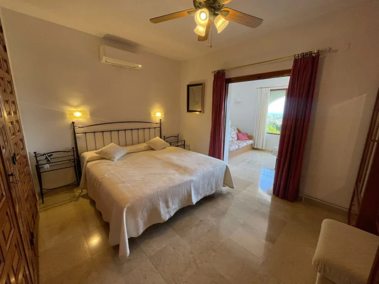 Spacious bedroom with adjoining living area inside a villa in Empedrola, Calpe.