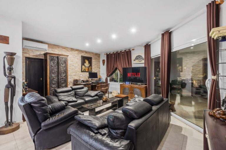 Spacious living area inside an independent apartment of a Benissa sea view villa with leather sofas, large windows and terrace access