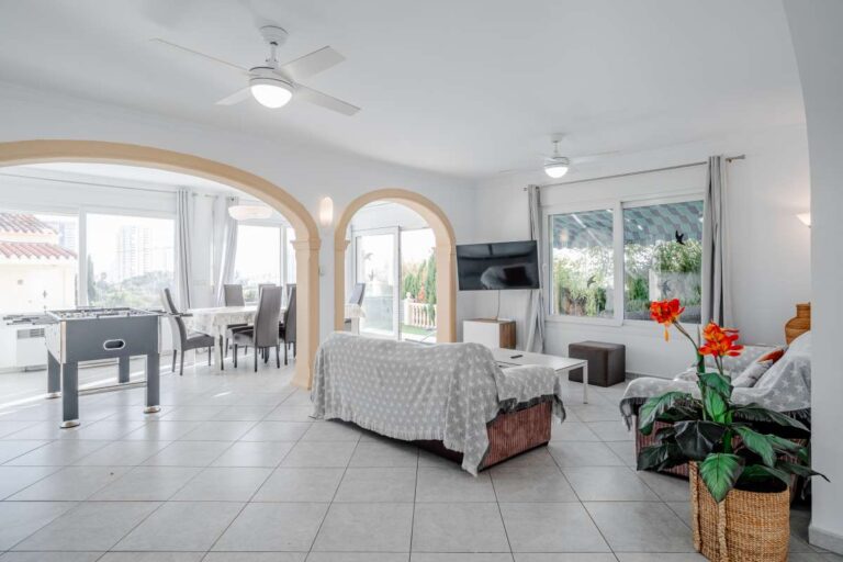 Spacious living area with kitchen, dining space and natural light inside a villa in Calpe