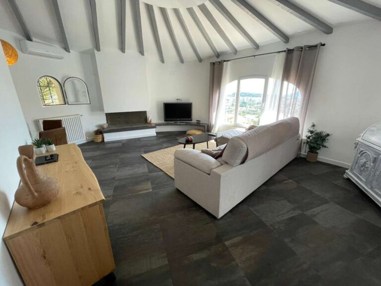 Spacious living area with vaulted ceiling, sofa and natural light inside a refurbished villa in Canuta, Calpe.