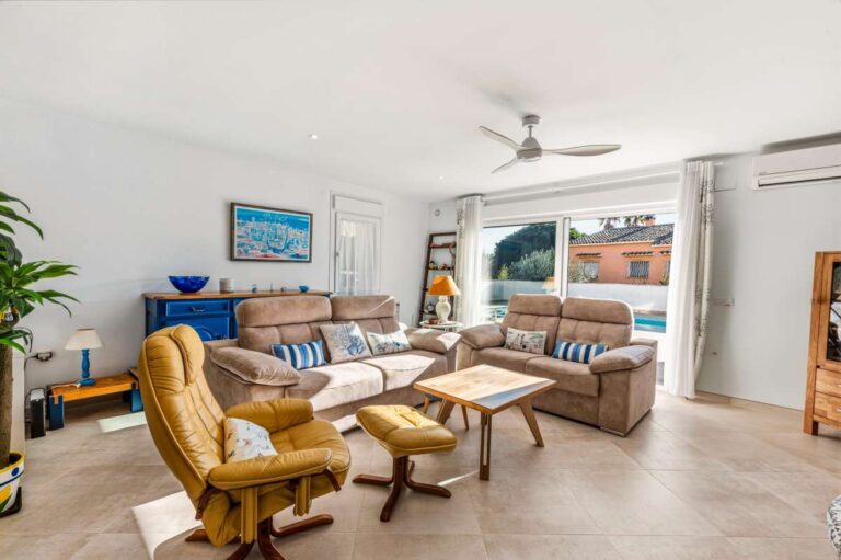 Spacious living room with sofa, armchair and natural light inside a contemporary villa in Calpe.