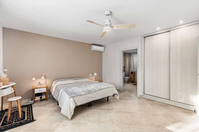 Spacious master bedroom with fitted wardrobes, air conditioning and ceiling fan inside a contemporary villa in Calpe.
