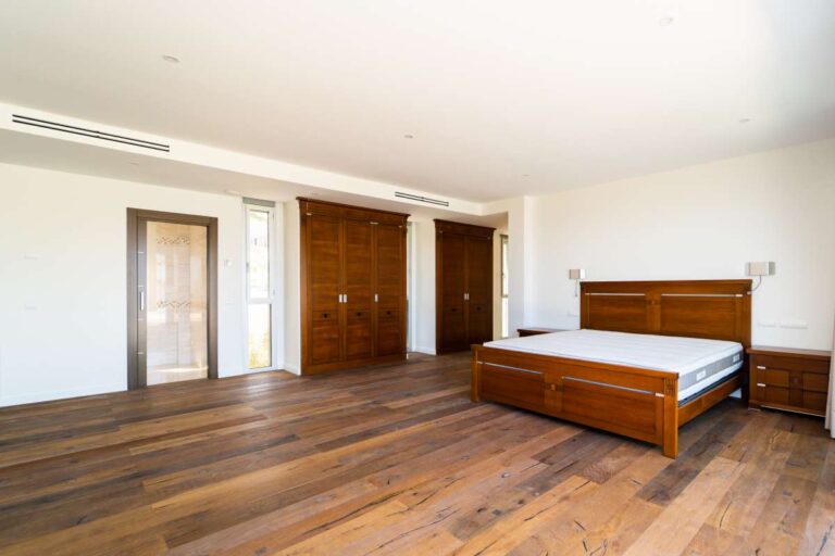 Spacious principal bedroom inside a luxury villa in Calpe with wood flooring, fitted wardrobes, en-suite access and natural light