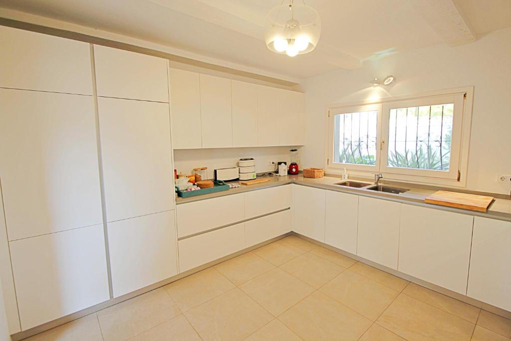 Spacious white kitchen with large windows at villa in Moraira