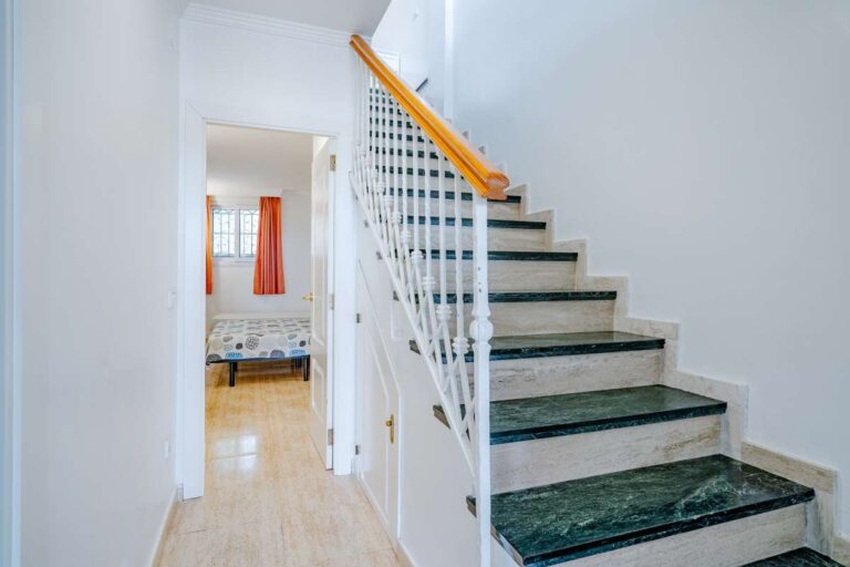 Staircase inside a duplex apartment near Les Platgetes Beach in Moraira connecting the two levels with bright white walls and tiled flooring