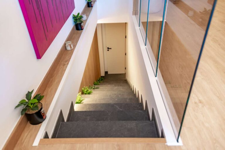 Staircase inside a luxury frontline beach duplex in Mascarat, Altea leading to the lower level with glass railing and modern lighting