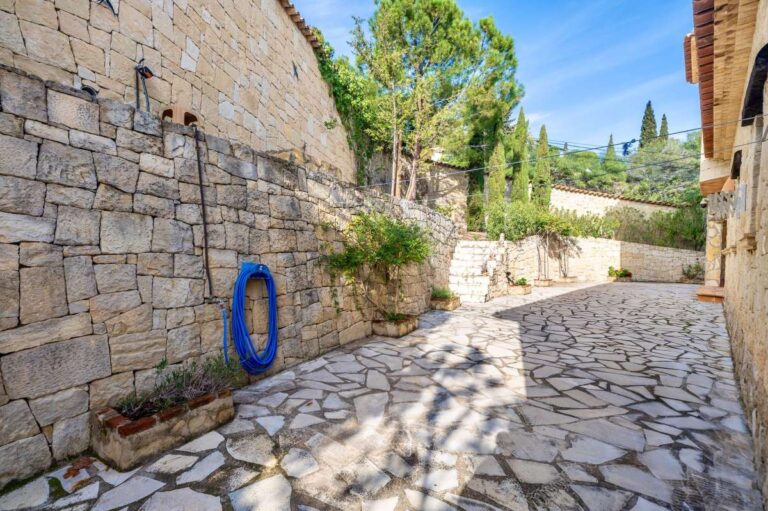 Stone driveway at a finca-style villa in Benissa Costa with natural stone walls, paved access, Mediterranean planting and rustic exterior details