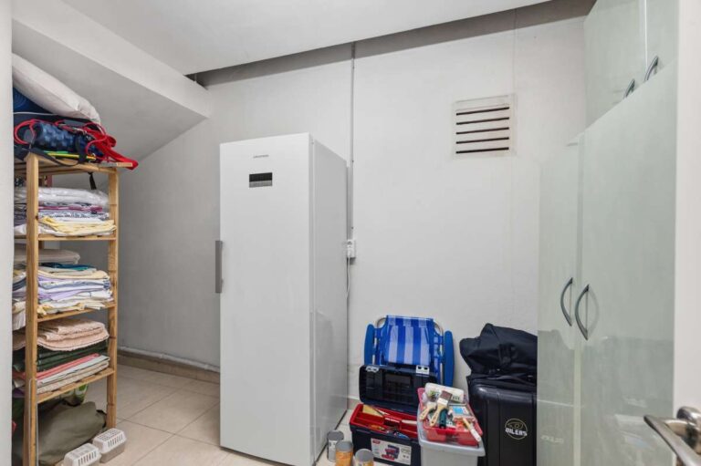 Storage room with shelving and utility space inside the lower level of a villa in Calpe.