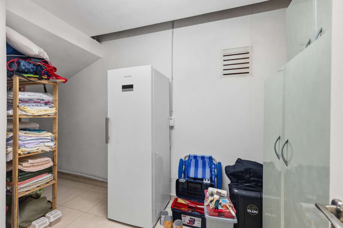 Storage room with shelving and utility space inside the lower level of a villa in Calpe.