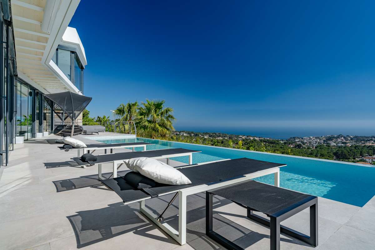 Sun loungers beside the infinity pool with panoramic sea views at a luxury villa in Gran Sol, Calpe.