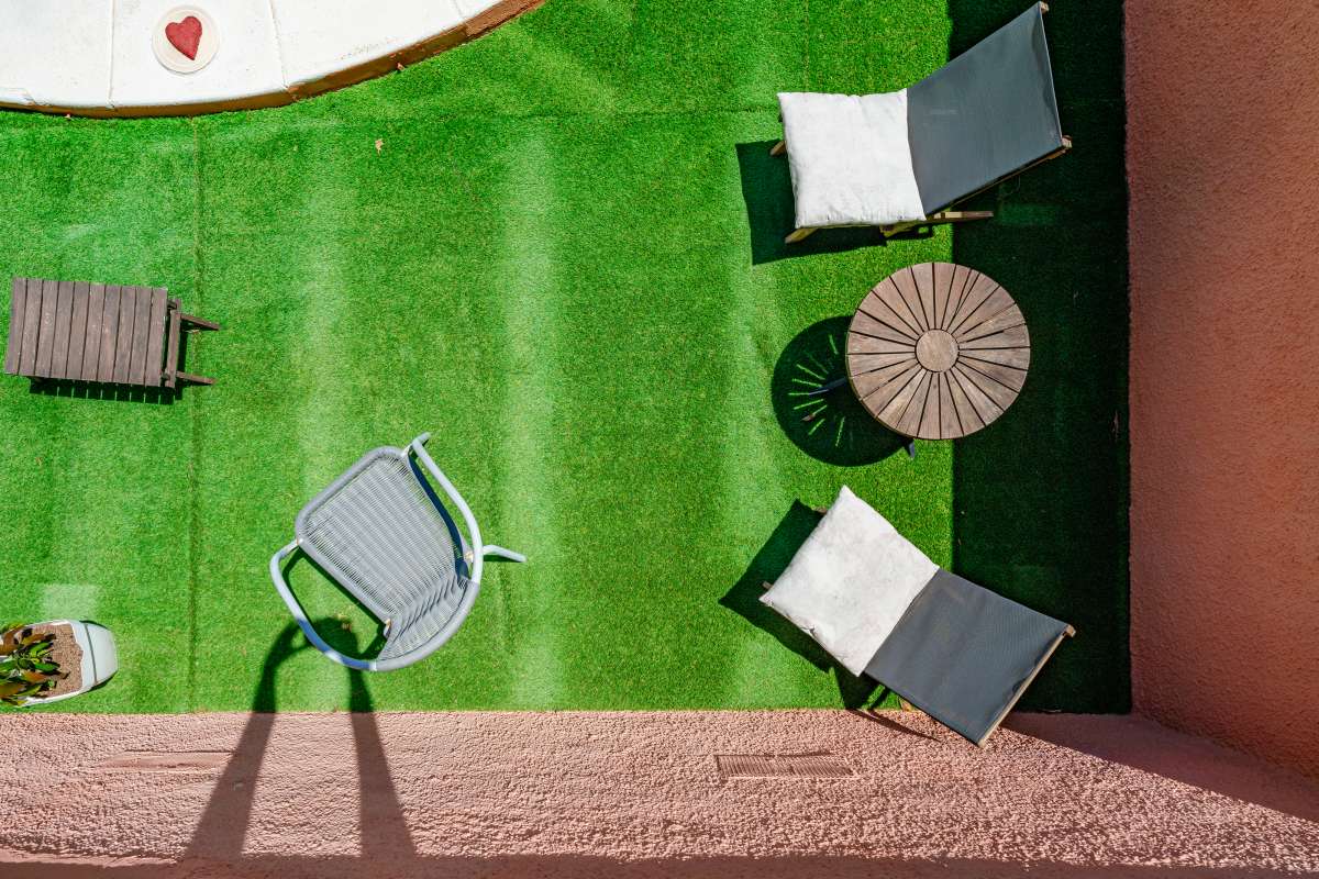 Sun lounging area with artificial grass beside the private pool at a renovated Mediterranean villa in La Cometa, Calpe.