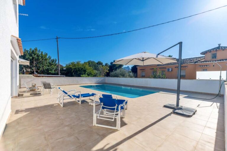 Sunny pool terrace with sun loungers at a contemporary villa with private swimming pool in Calpe.