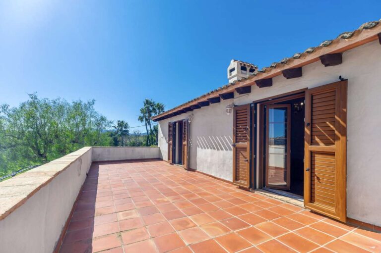 Terrace at a traditional Spanish finca near Moraira with bedroom access, wooden shutters, tiled flooring and countryside surroundings