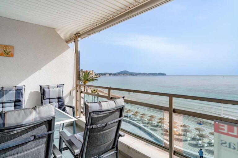 Terrace dining area at a beachfront apartment by La Fossa Beach in Calpe with outdoor chairs, table and open Mediterranean Sea views