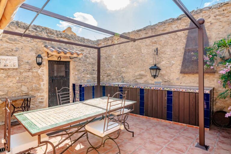Terrace dining area at a historic finca in Benissa with stone walls, outdoor table, Mediterranean planting and rustic character